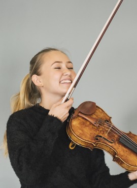 Jonna Simonsson håller i en fiol och skrattar