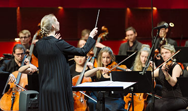 En dirigent som leder en symfoniorkester. Foto: Mira Åkerman