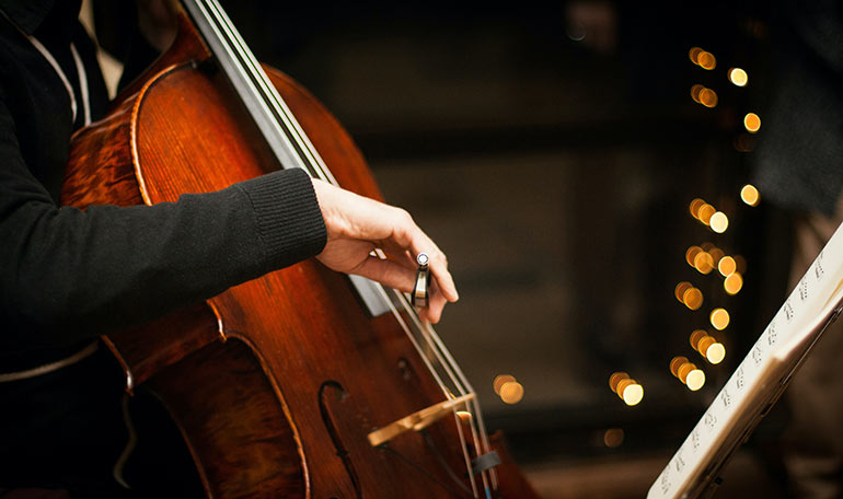 Närbild på en person som spelar cello