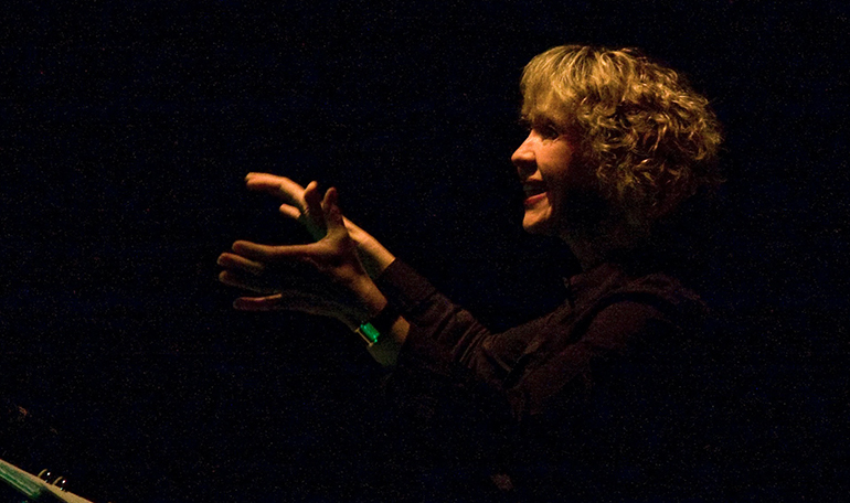 Ann-Britt Werner dirigerar en kör. Kören syns inte på bilden.