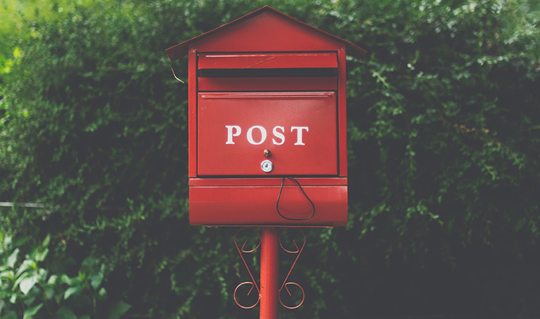 Röd brevlåda märkt "Post".