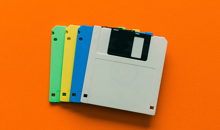 Fyra disketter i olika färger ligger i en hög